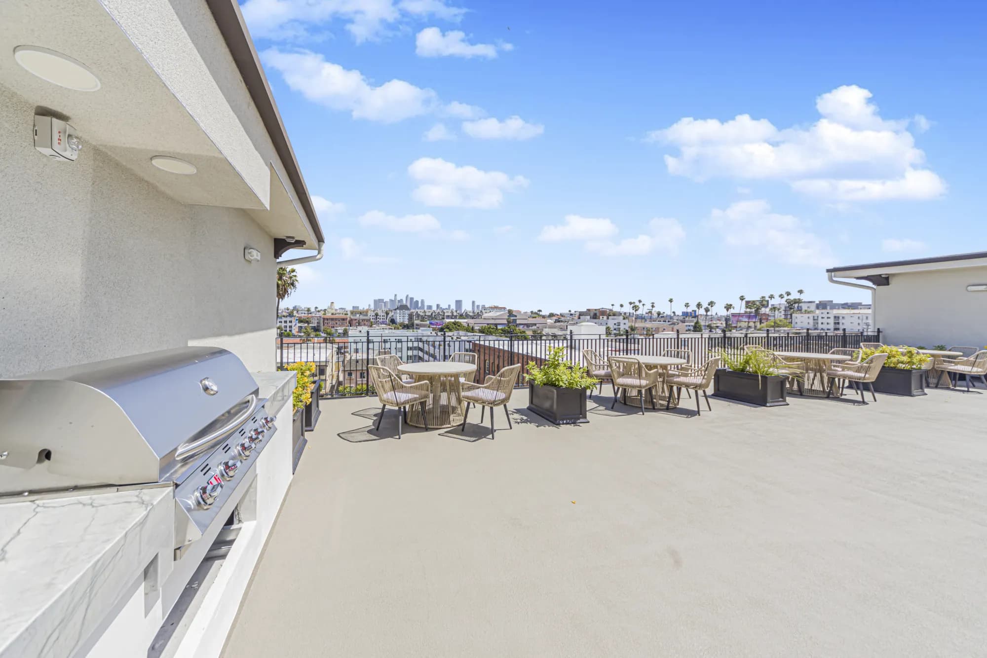 Rooftop grill and outdoor dining area with skyline views at The Gramercy